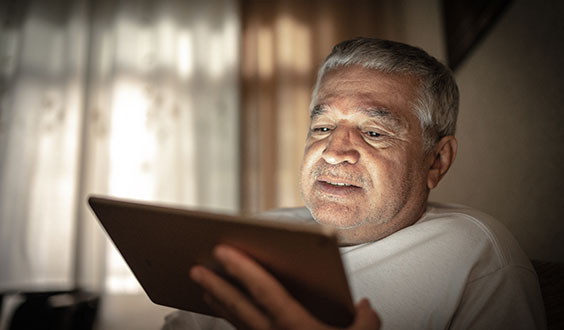 Latino man looking at tablet